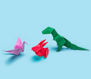Origami of three dinosaurs on blue background