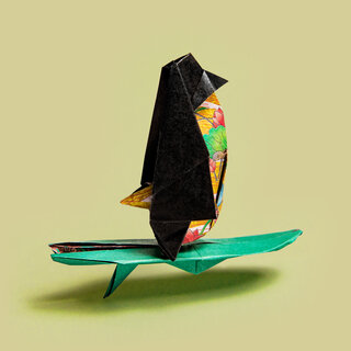 Origami penguin on a surfboard