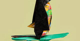 Origami Pinguin auf einem Surfbrett