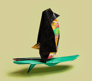 Origami penguin on a surfboard