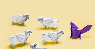 Origami von 5 Schafen vor einem Wolf