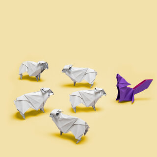 Origami von 5 Schafen vor einem Wolf