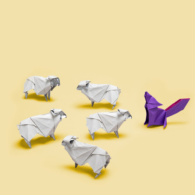 Origami of 5 sheep facing a wolf