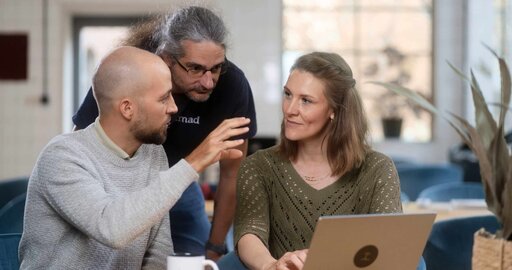 Image of three people discussion work