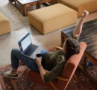 Image of a person sitting on a chair working on a laptop