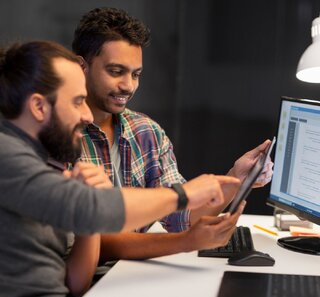 Image of two people working together on something