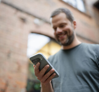Image of a person checking their mobile phone while on the go